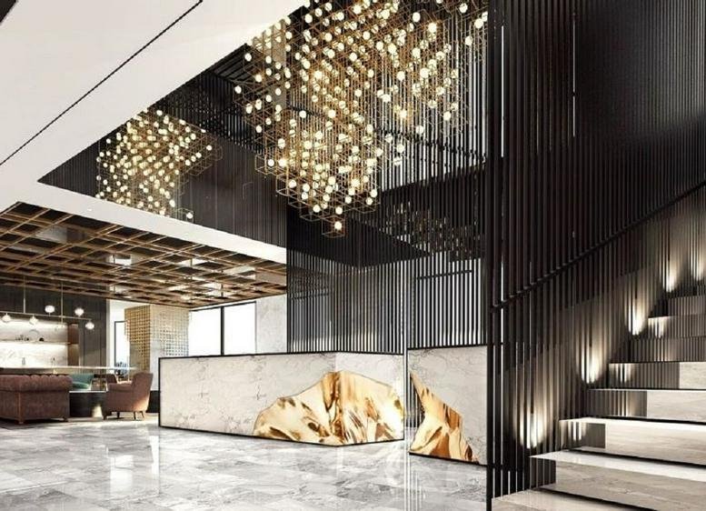 Grand lobby and marble reception desk at Gem Tower featuring a dramatic multi-layered crystal light installation.