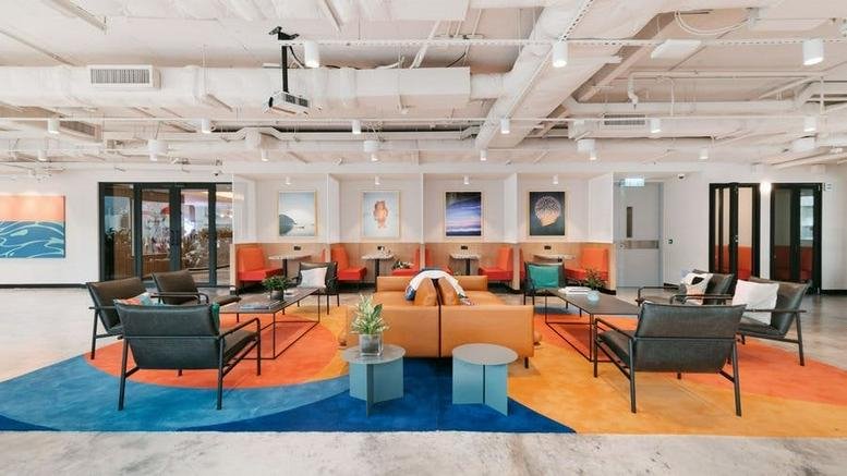 Spacious communal lounge at Hub 71, Al Khatem Tower featuring modern seating and a large patterned rug.