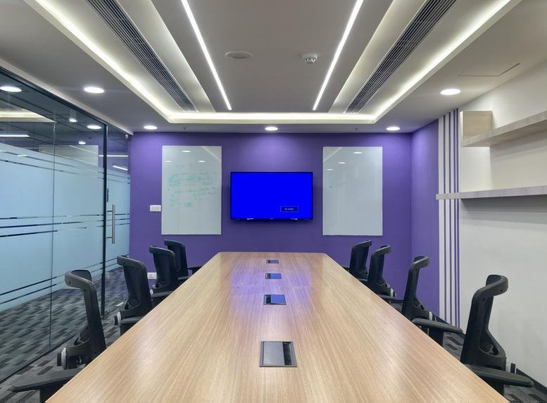Sleek conference room with purple walls and a long wooden table at iLabs Centre.
