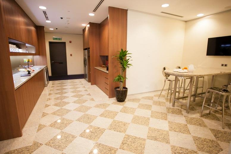 Spacious corridor with checkered flooring and seating area.
