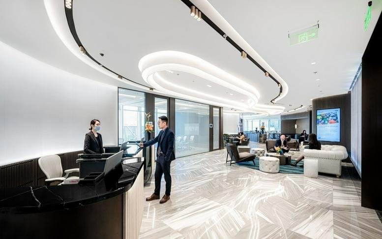 Modern reception area with a curved ceiling light and marble floors.