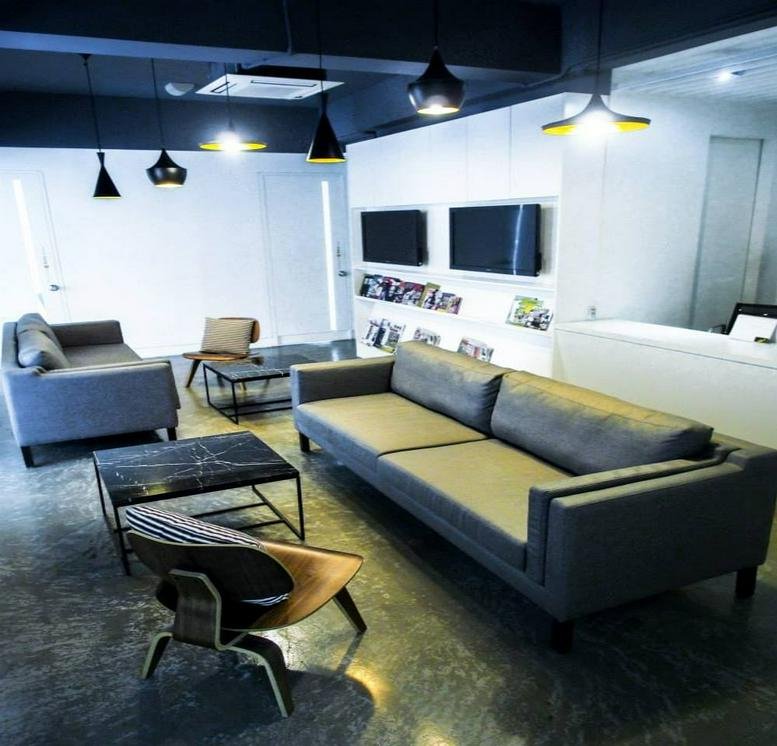Spacious lounge at IOI Boulevard with modern grey sofas, marble coffee tables, and designer pendant lighting.
