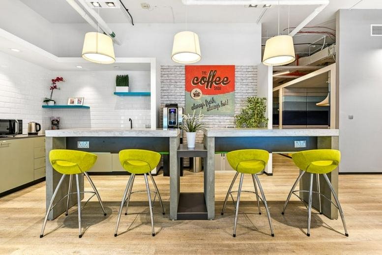 Iris Bay Tower breakout area with lime green bar stools and a coffee station.