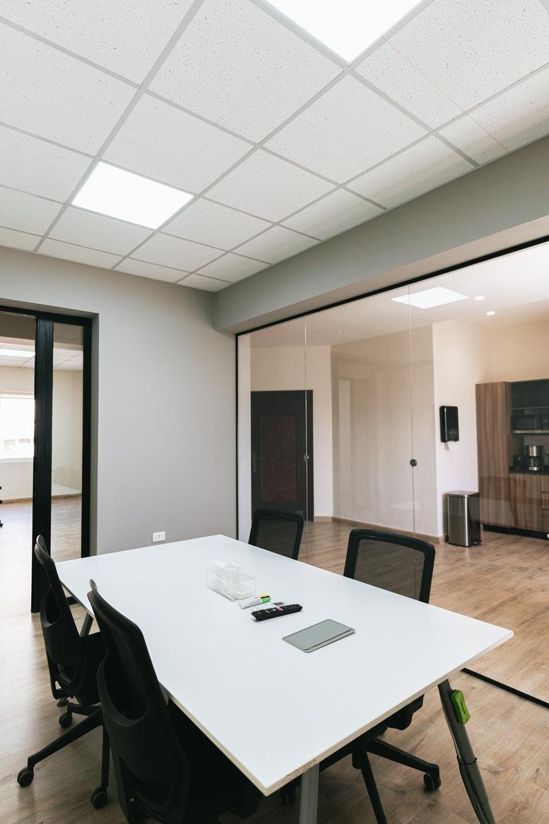Private office suite at Issam Al-Ajlouni Street, Amman with a white meeting table and black chairs.