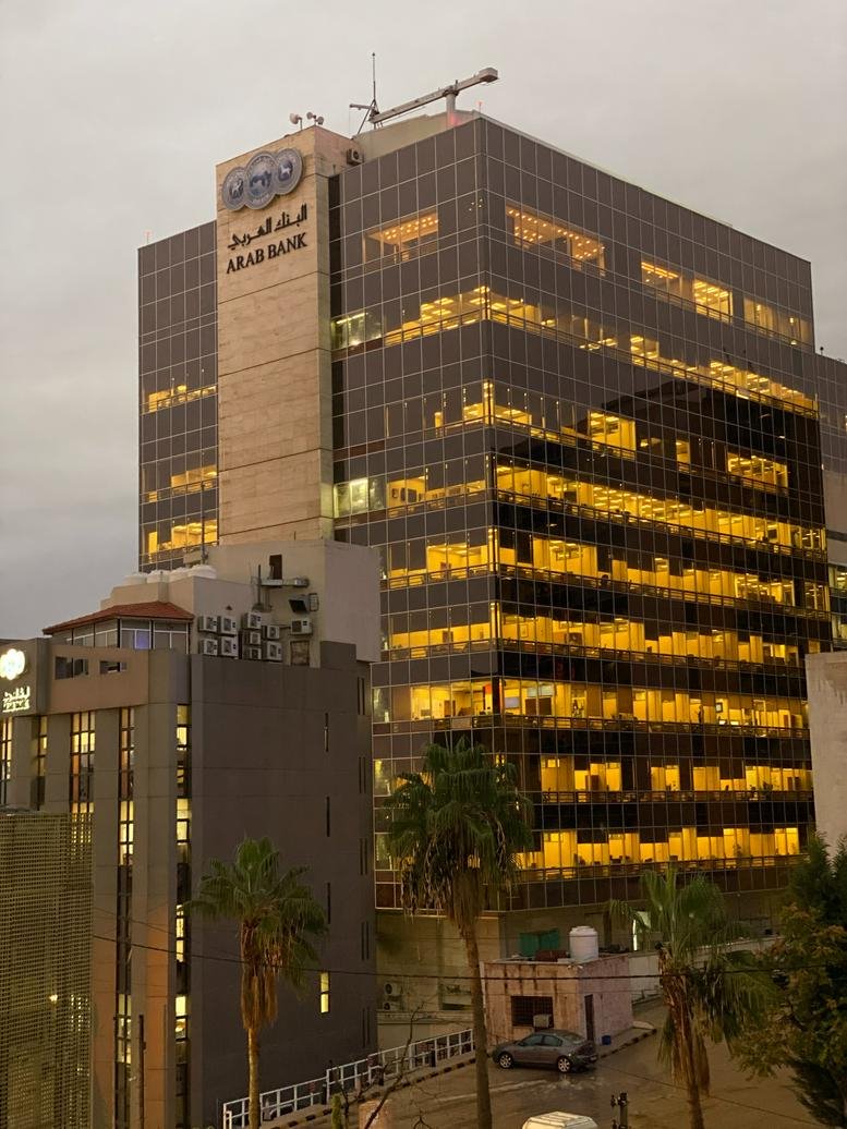 Multi-story glass building with gold-tinted windows reflecting evening light.