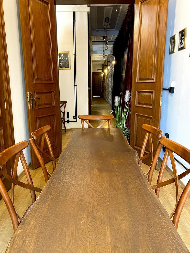 Meeting room at Istiklal Cd. 189 Tomtom Mh. Beyoğlu with a long live-edge wooden table and classic chairs.