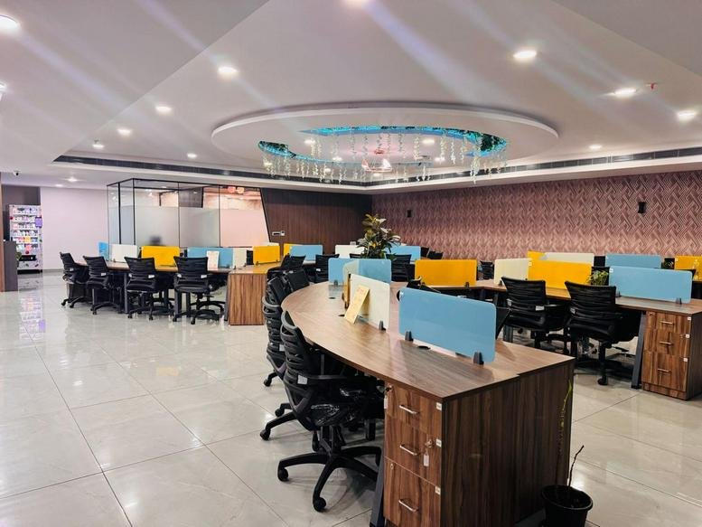 Spacious open-plan workspace at Jain Sadguru Images Capital Park with modern workstations and decorative lighting.