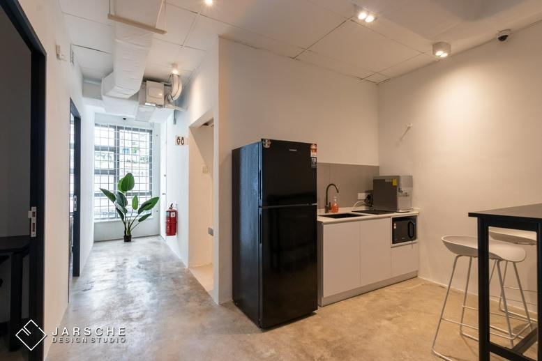 Spacious communal kitchen and dining area at No. 5-2 (Level 2), Jalan Kuchai Maju 8 with a black fridge and potted plant.