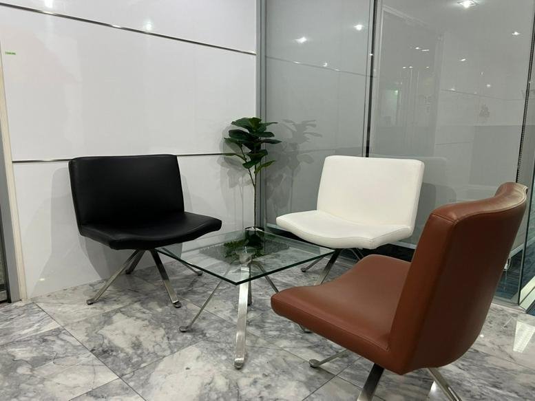 Jasmine City Building lobby lounge with modern black, white, and brown leather armchairs.