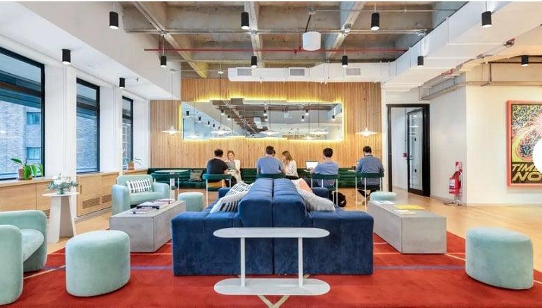 Spacious communal lounge at Jogeshwari-Vikhroli Link Road Andheri East Mumbai with blue seating and red rugs.