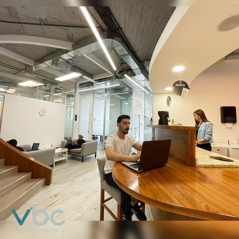 Casual breakout area with a wooden curved counter and comfortable lounge seating.