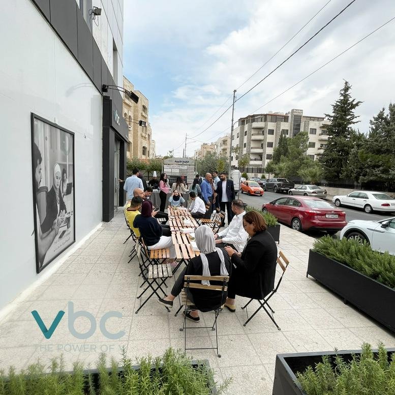 Exterior patio area of the VBC Center at Princess Zeinab Bent Al-Hussein Street with people sitting at tables.