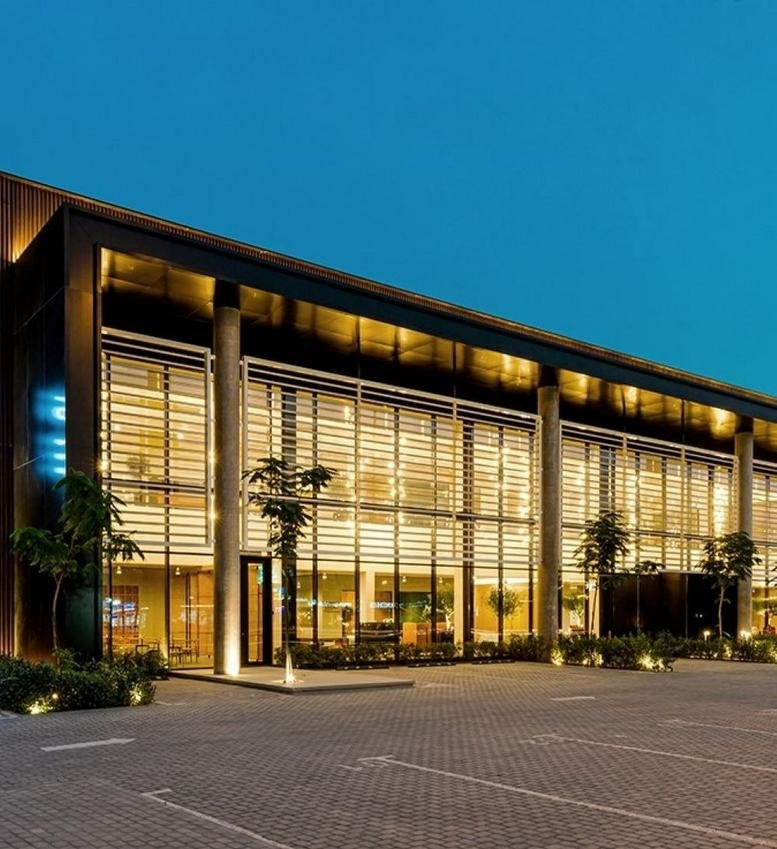 Exterior view of the modern, glass-fronted King Abdulaziz Road building at dusk.