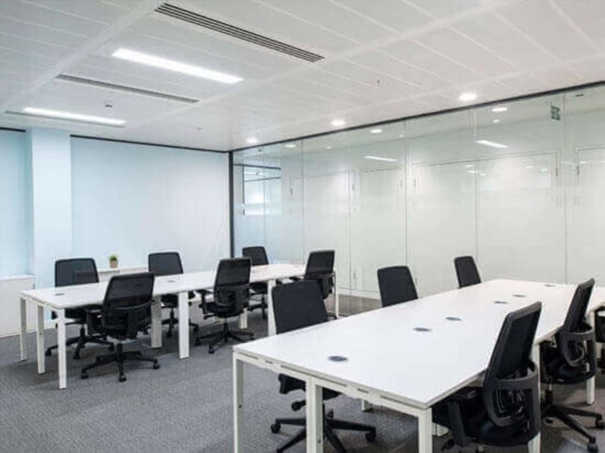 Spacious open-plan workspace at King Abdullah Branch Road with rows of white desks and black ergonomic chairs.