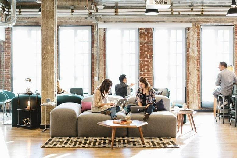 Spacious communal lounge with exposed brick walls, comfortable seating, and large windows at King George St 20.