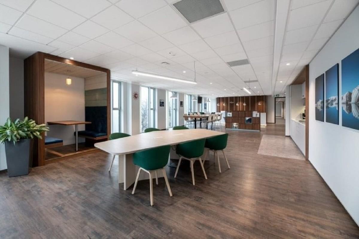 Bright communal lounge at Kokos Korea, Point 23 with wood-style flooring and green velvet chairs.