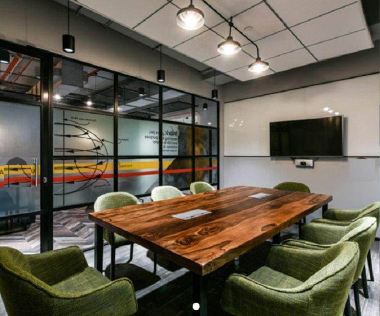 A professional board room at Augusta Point (L2 & L3), Sector 53 Golf Course, Gurugram with a large wooden table.