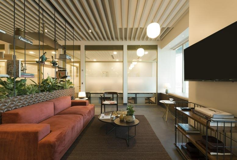 Spacious lounge at L6 Peninsula Towers with a rust-colored velvet sofa and stylish wood slat ceiling.