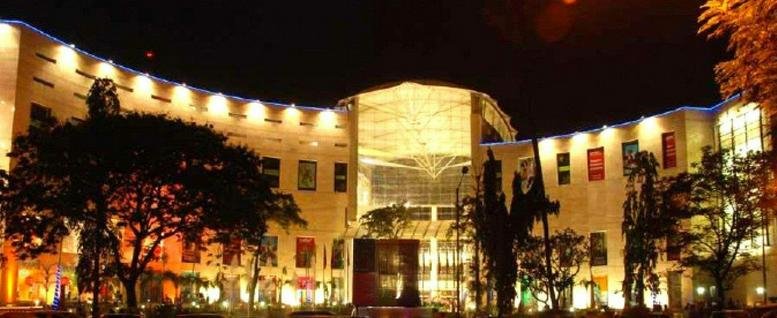 Nighttime exterior view of the illuminated facade of RCity Offices adjoining RCity Mall.