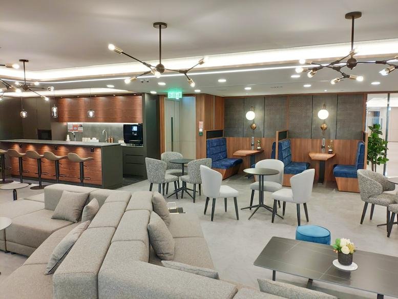 Spacious communal lounge with diverse seating, café bar, and designer lighting.