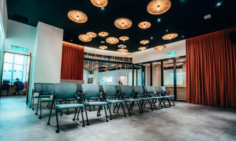 Spacious event or seminar space at Tropicana Gardens Mall with rows of teal chairs and unique circular ceiling lights.