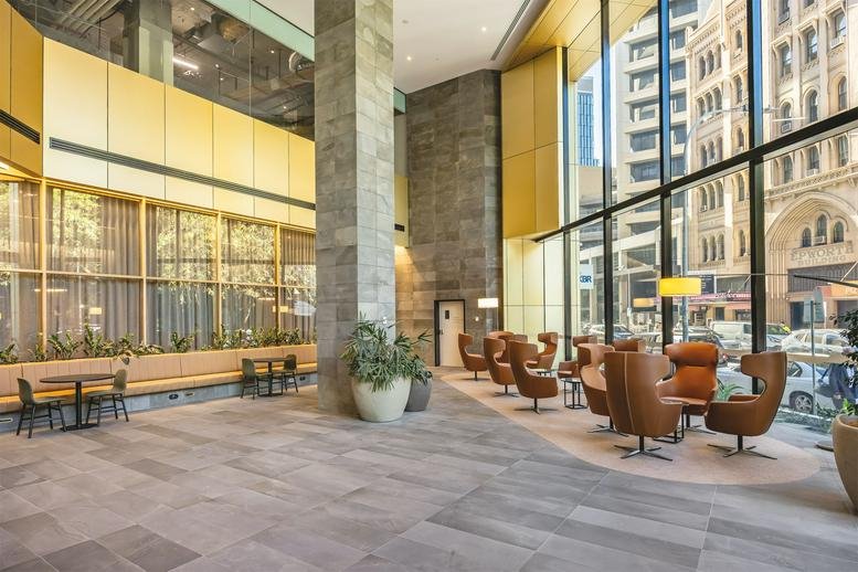 Spacious sunlit lobby at M/30, Pirie Street, Adelaide, South Australia with warm wood paneling and leather seating.