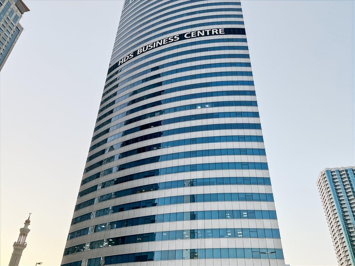 Exterior view of the curved glass facade of HDS Tower in the daytime.