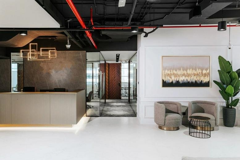 Reception area at Mazaya Business Centre AA1 with a sleek front desk and comfortable lounge seating.