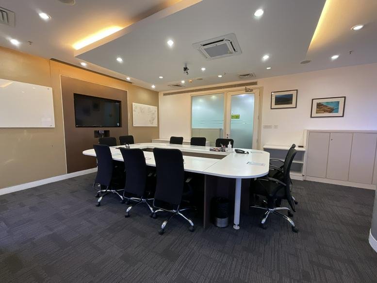 Professional conference room with a large white table and integrated AV equipment.