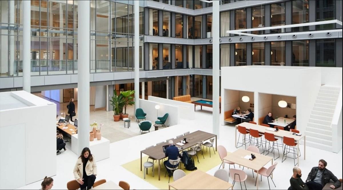 Spacious, sunlit multi-level atrium at Menara Merdeka 118 featuring varied seating and white structural columns.