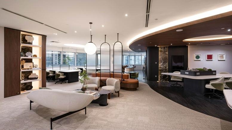 Spacious communal lounge at Level 28, Menara Southpoint with white armchairs and marble coffee table.