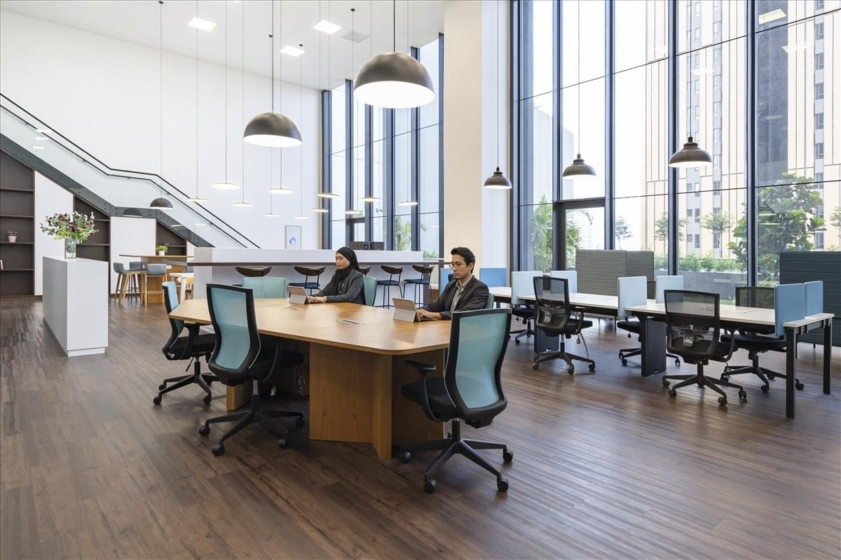Modern coworking area with warm wood floors and high ceilings.