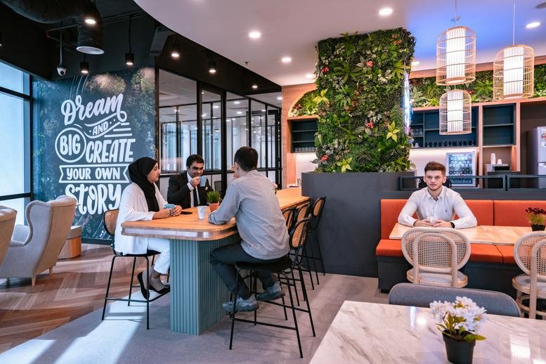 Vibrant communal cafe area at Menara UOA Bangsar with a chalk art wall and hanging wicker lamps.
