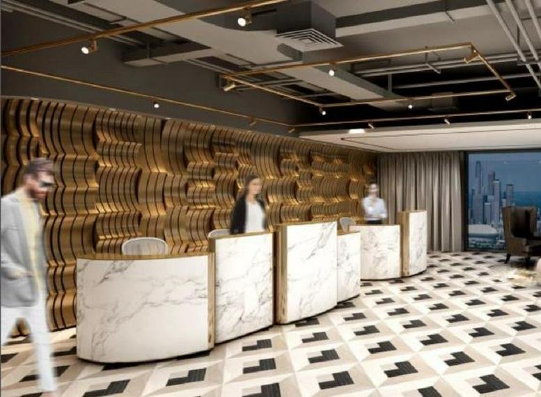 Spacious reception area at Metropolitan Oriental Plaza with marble desks and a gold textured feature wall.