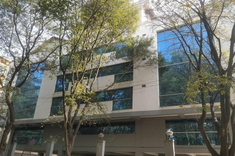Exterior view of the modern glass-facade building at Miniforest, 1st Main Road, Sarakki Industrial Layout.