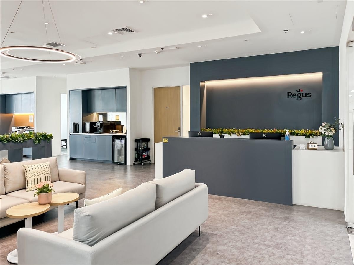 Spacious reception area at WHA Tower with a modern grey desk and comfortable lounge seating.