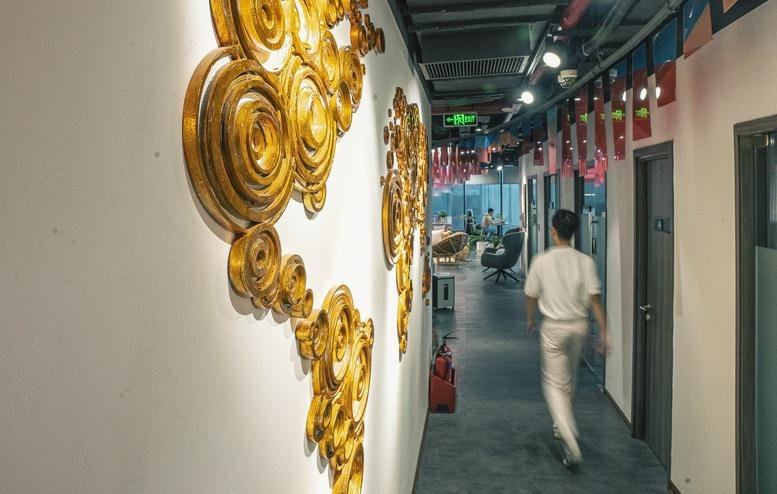 Bright hallway with gold spiraled wall art and red hanging banners near the N01-T4 Building office space.