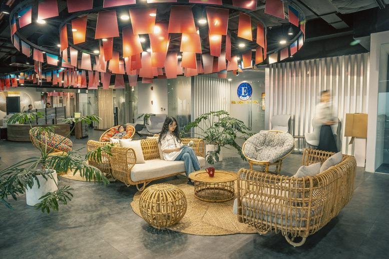 Spacious lounge at N01-T4 Building with wicker furniture and vibrant hanging ceiling decorations.