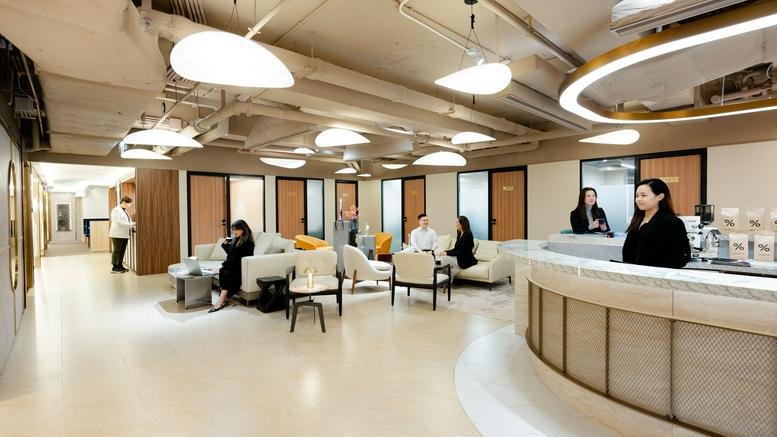 Spacious communal lounge area with mid-century modern furniture and warm designer lighting.