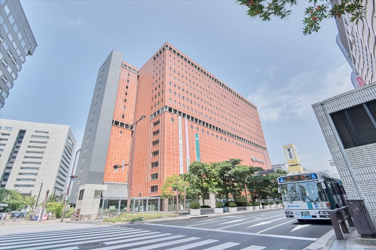 Exterior view of the Nishinihon Shinbun Building16F with its terracotta facade and large windows.