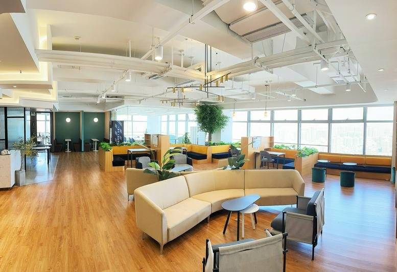 Spacious coworking lounge at Wucai International with curved seating and floor-to-ceiling windows.
