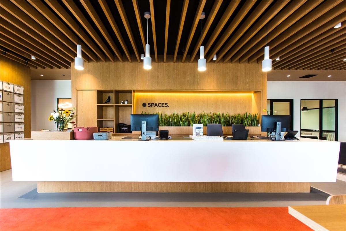 Bright reception desk at 1687/1 Phahonyothin Road with wood paneling and minimalist white counter.