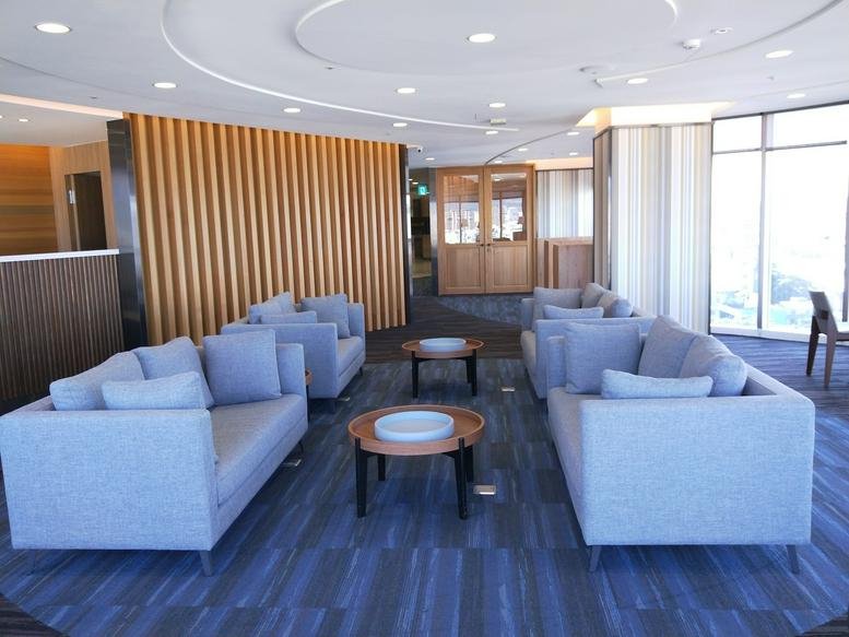 Spacious communal lounge at 186, Section 4, Fuxing Road, East District, Taichung City with grey sofas.