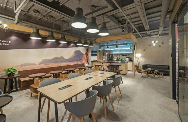 Spacious communal lounge and coworking area at Yishujia Workshop with warm lighting and wooden accents.