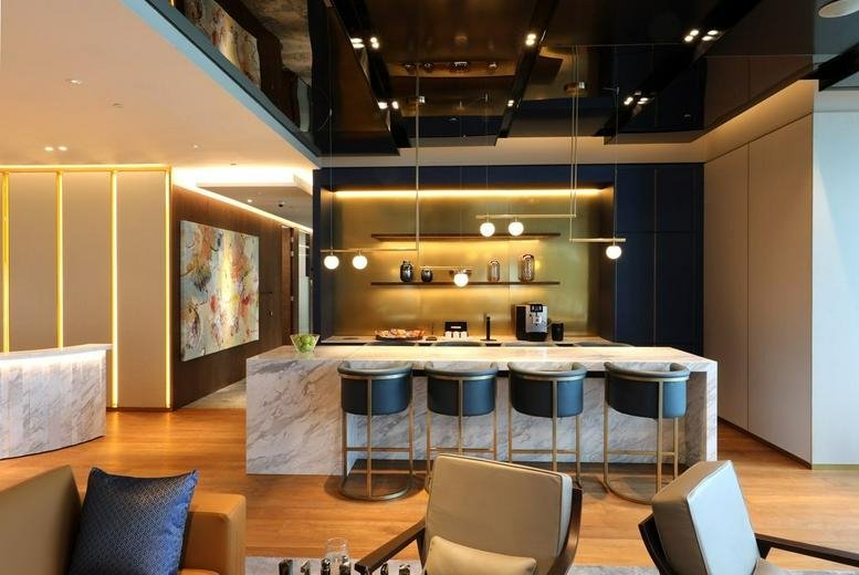Modern communal lounge and marble bar with designer lighting and warm wood flooring.