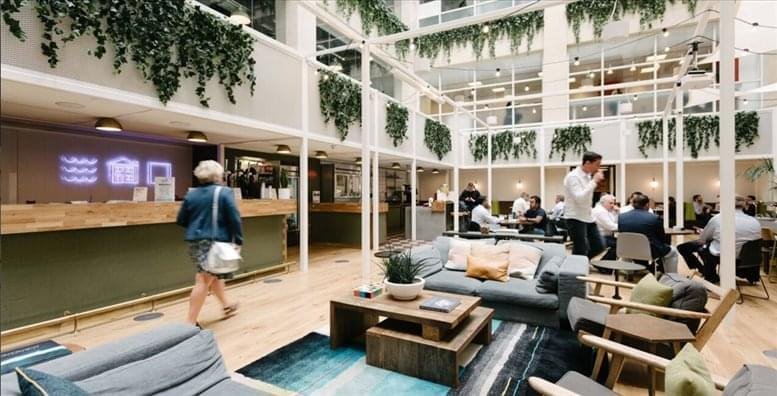 Spacious lounge with modern decor and hanging plants.