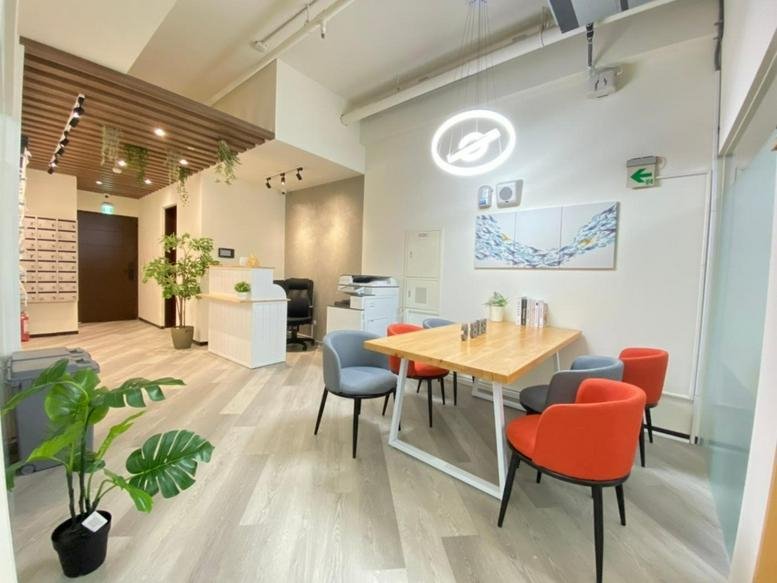 Reception area at No. 57, Nanjing West Road, featuring a sleek front desk, ring pendant light, and indoor plants.