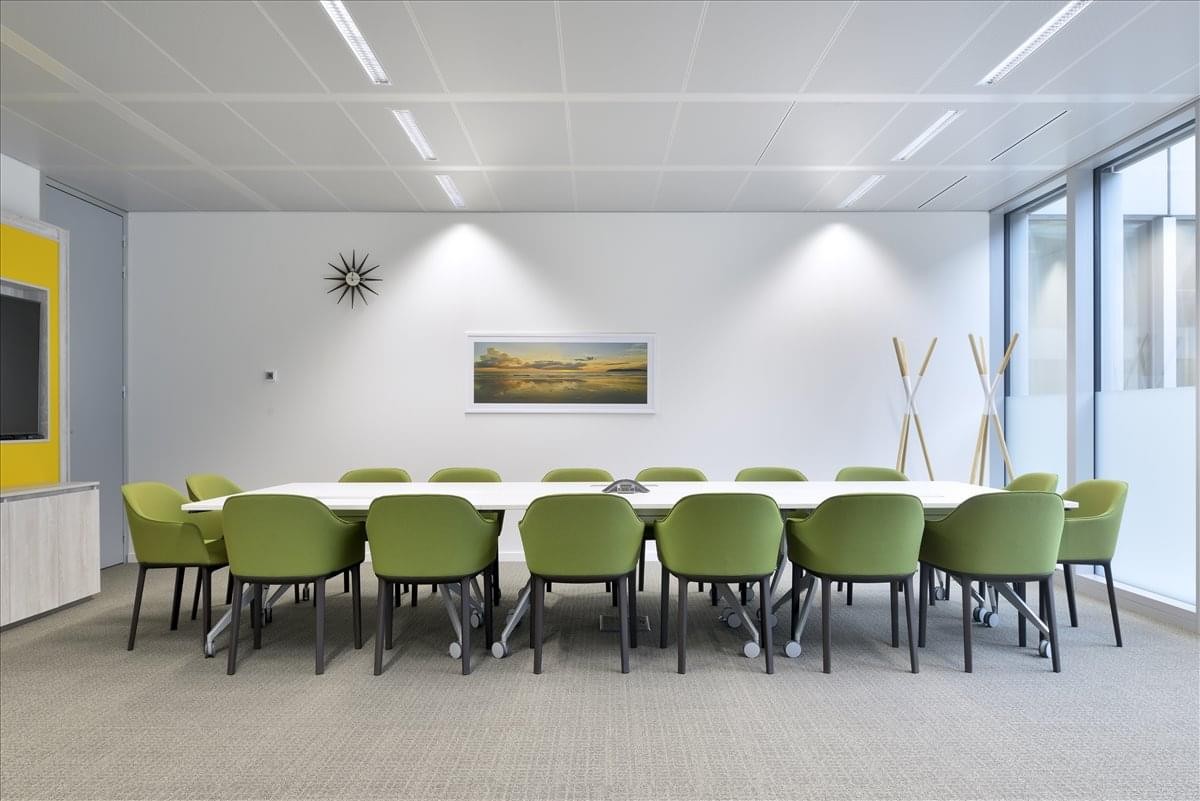 Spacious boardroom with green chairs and minimalist wall art at No. 7000 Jingshi Road, Shunhua Road Street.