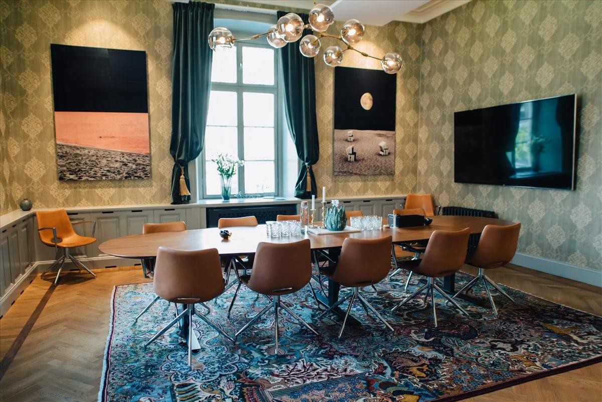 Grand boardroom at Capitol Piazza featuring patterned wallpaper and a long oval table.