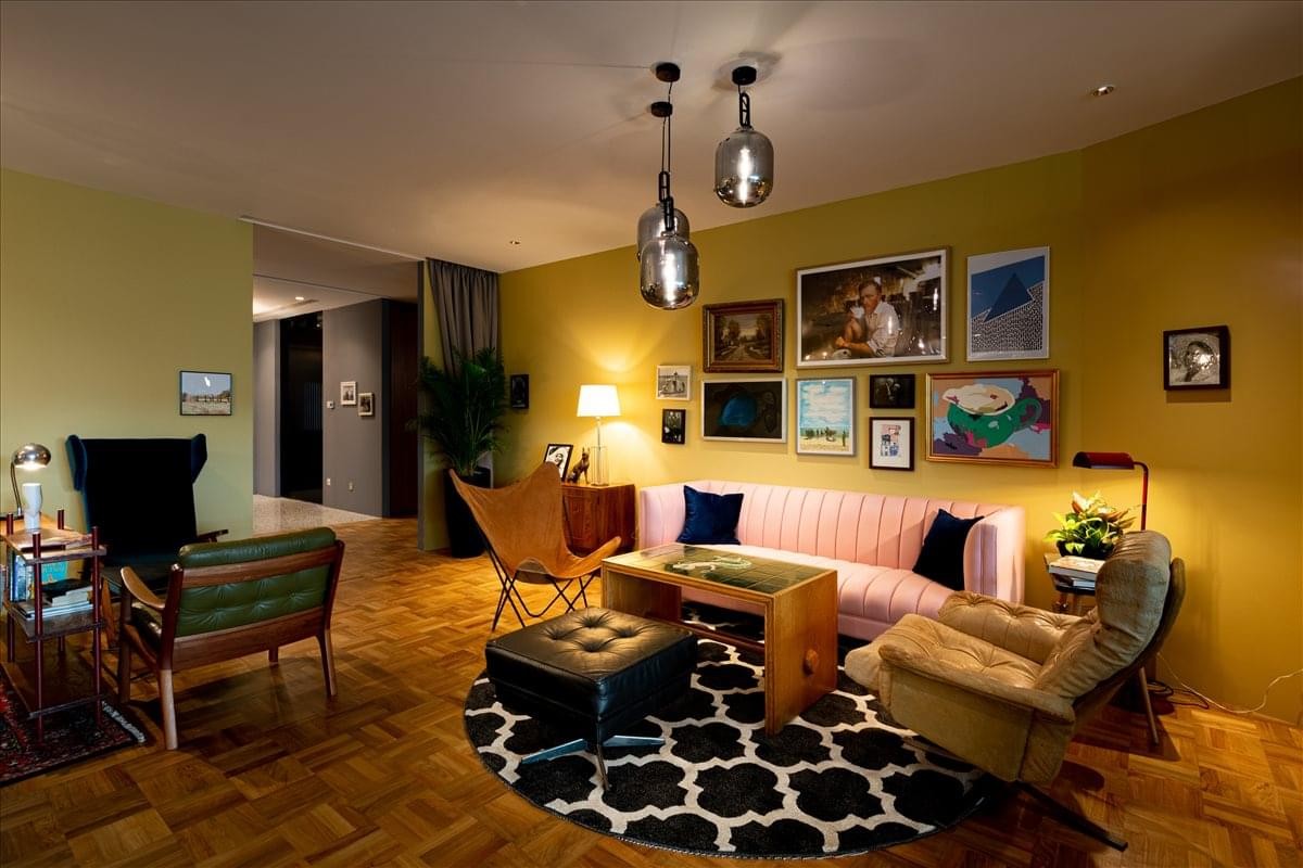 Common area at Luxury Office Spaces in Capitol Piazza featuring a pink sofa and colorful gallery wall.